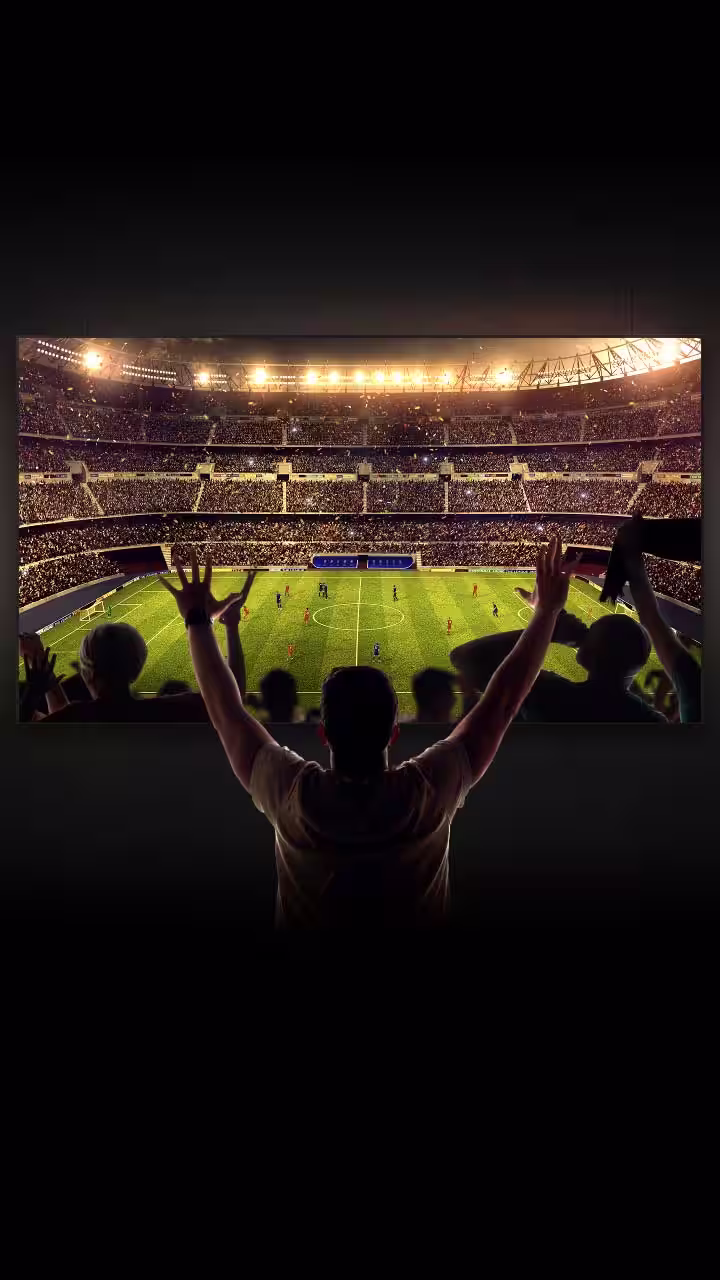4 people celebrate on a couch as a soccer game plays on the large LG OLED television